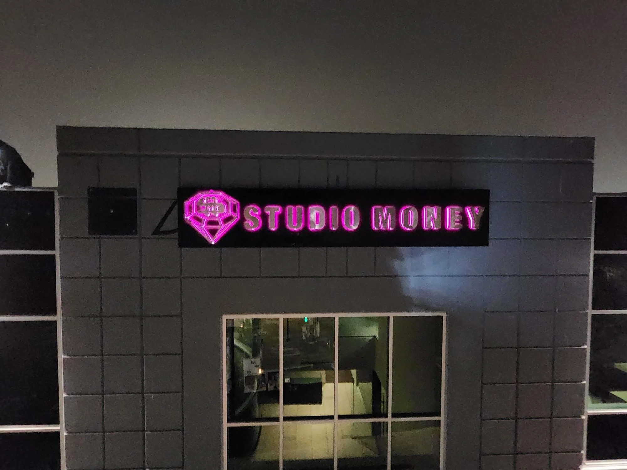 Studio Money flagship training facility entrance with neon sign in Carlsbad, CA